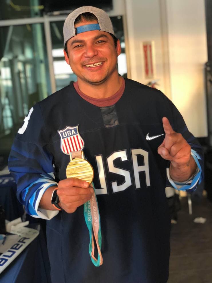 Ralph DeQuebec holding Inspire Games medal